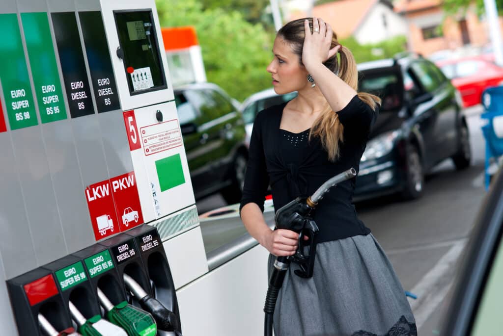 Young female looking concerned after putting petrol in her car
