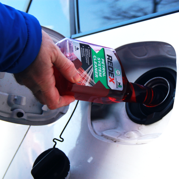 Pouring redex petrol system cleaner into car tank