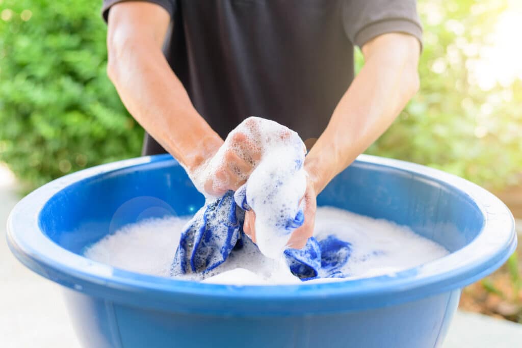 Male washing clothes in soapy water